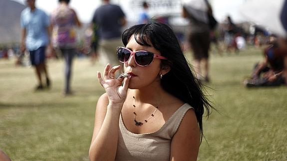 Una joven fuma un cigarrillo de marihuana. 