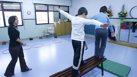 Dos niños autistas realizan ejercicios de psicomotricidad.