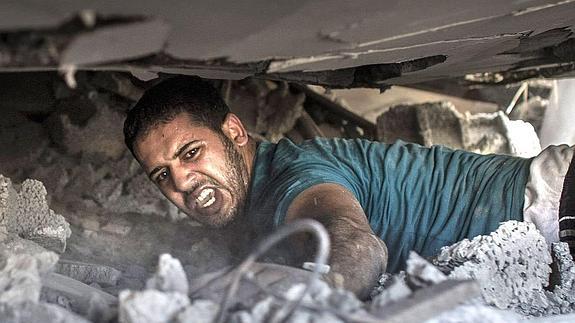 Un palestino busca supervivientes entre los escombros de una casa destruida por un ataque aéreo israelí. 