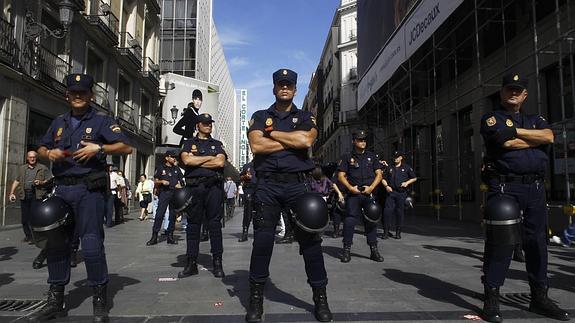 Policías nacionales vigilan la calle comercial de Preciados, en Madrid.