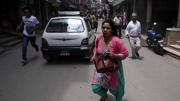 Nepalíes corren tras el terremoto. 