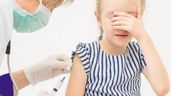 Una niña en proceso de vacunación.