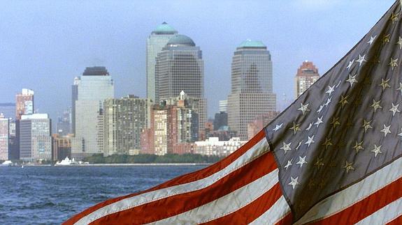 Bandera de Estados Unidos y tras ella la vista de Manhattan sin las Torres Gemelas tras los atentados del 11-S.