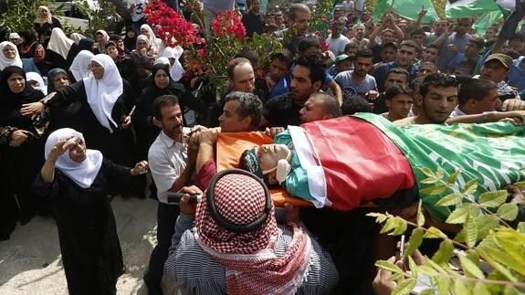 Varios palestinos llevan el cadáver de un joven de 18 años.