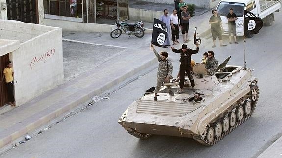 Miembros del Estado Islámico desfilan con su tanque por una calle de la ciudad siria de Raqa. 