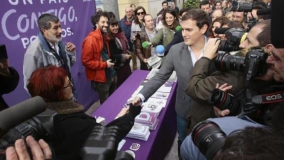 Rivera saluda a unos integrantes del grupo de Podemos durante su visita a Guadalajara.