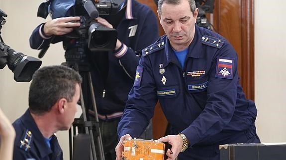 El jefe de la Comisión de Investigación de Accidentes Aéreos rusa sostiene la caja negra del bombardero. 