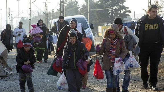 Un grupo de refugiados cruza la frontera entre Grecia y Macedonia.