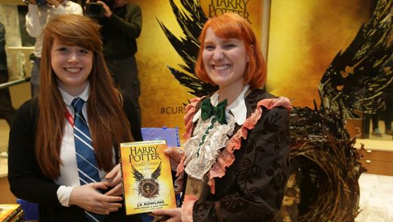 Fans de Harry Potter posan con el nuevo libro. 