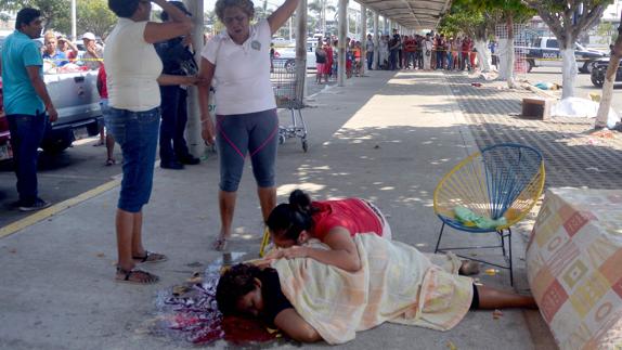 Una mujer llora sobre un familiar asesinado. 