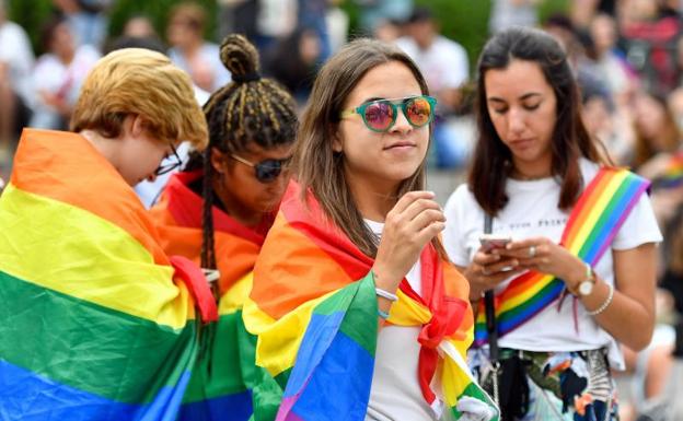 Un grupo de jóvenes ataviadas con banderas arcoíris en Chueca.