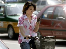 Una mujer china consulta su teléfono móvil.