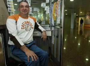 TRABAJO.  Miguel en su puesto de venta del cupón de la Once del Hospital San Agustín. / MARIETA