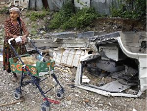 XENOFOBIA. Una gitana se apoya en un coche de bebé, junto a sus pertenencias quemadas. / REUTERS