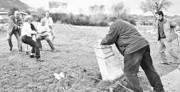 Varios afectados levantan el monolito que fue trasladado durante la urbanización de los terrenos. / NEL ACEBAL