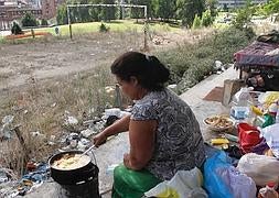 Rosa María Giménez prepara la comida en el antiguo campo de fútbol cerca de Pando. ::                             M. ROJAS