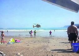 El helicóptero del Grupo de Rescate de los Bomberos de Asturias en la playa de Cadavedo. ::                             E. C.