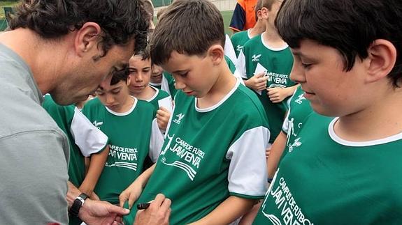 Javi Venta firma autógrafos a los niños que participan en su campus de fútbol.