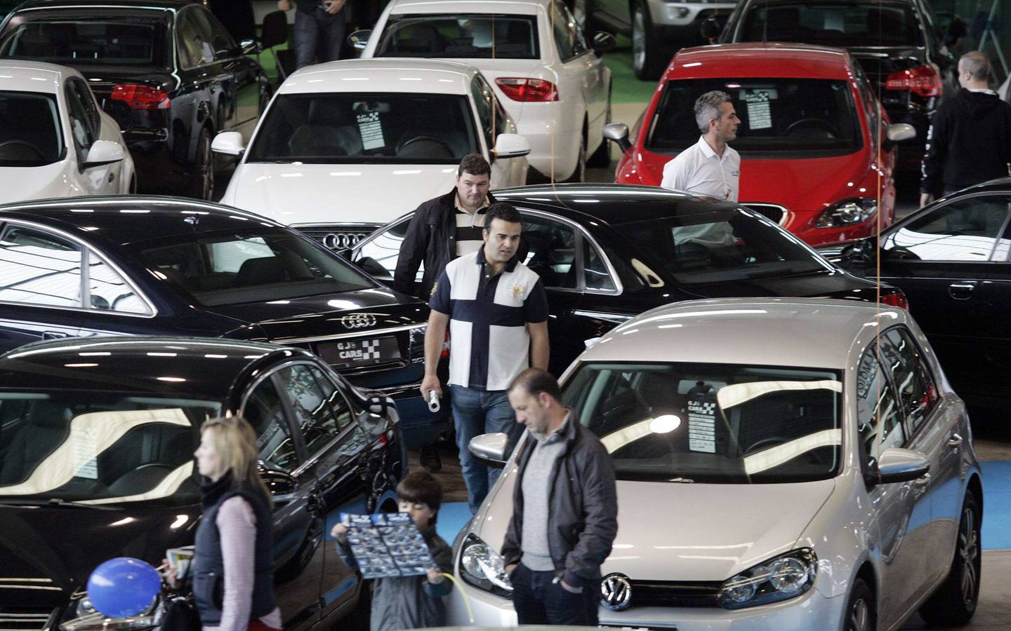 Visitantes de la edición de la Feria de 2013 recorren los expositores de vehículos de ocasión. 