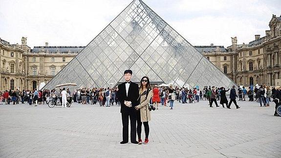 Viaja con una foto gigante de su padre fallecido y posa en lugares turísticos