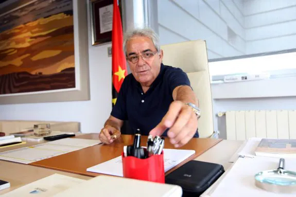 Avelino Suárez, con la bandera angoleña de fondo, en su despacho de Impulso, la empresa que preside. 