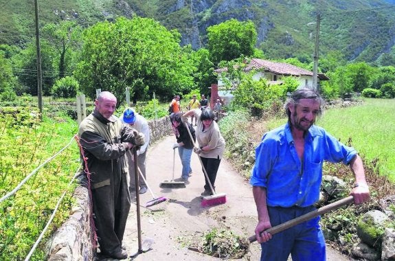 Vecinos de Selviella, limpiando uno de los caminos del pueblo. 