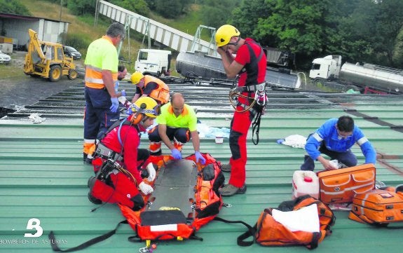 Los Bomberos sobre el tejado de la nave en la que cayó el herido. 