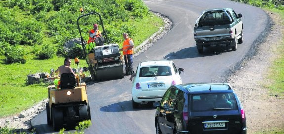 Vehículos particulares y maquinaria compartían ayer la carretera de acceso a los Lagos de Covadonga, en las curvas de la zona conocida como Teón. 