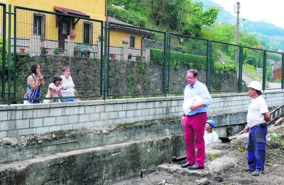 Unas vecinas entregan un currículum a los responsables de obra en el pozo. 
