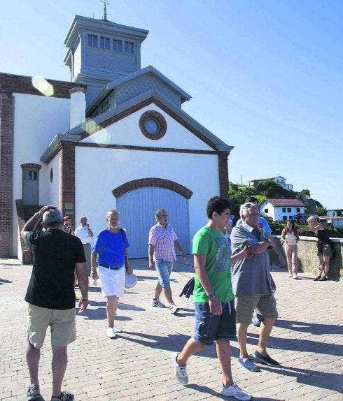 Un grupo de visitantes sale del castillete de Arnao. 