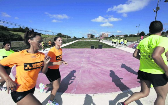 Un grupo de atletas corre por la pista poco después de su inauguración. 