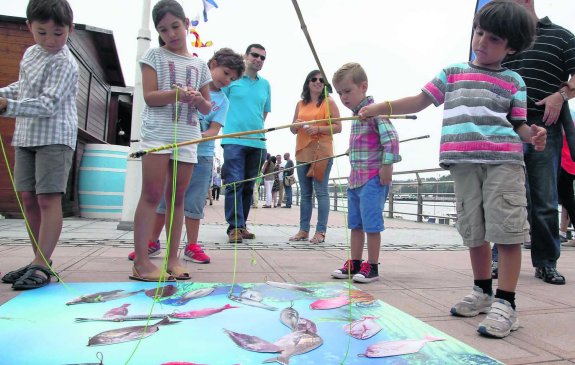 Varios niños se divierten con el juego de pesca instalado por Avante. 