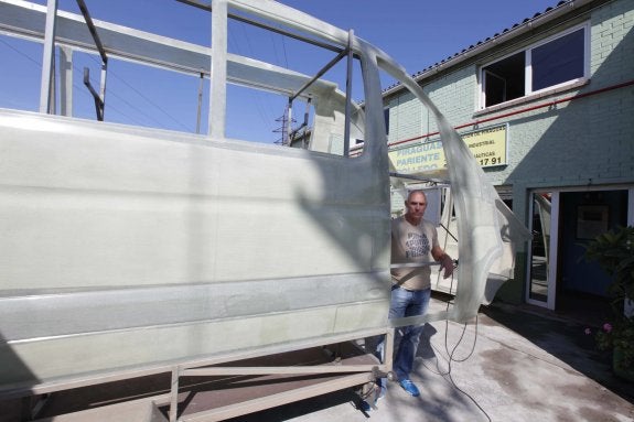 José María Pariente Polledo posa con un lateral de autobús fabricado en su empresa. 