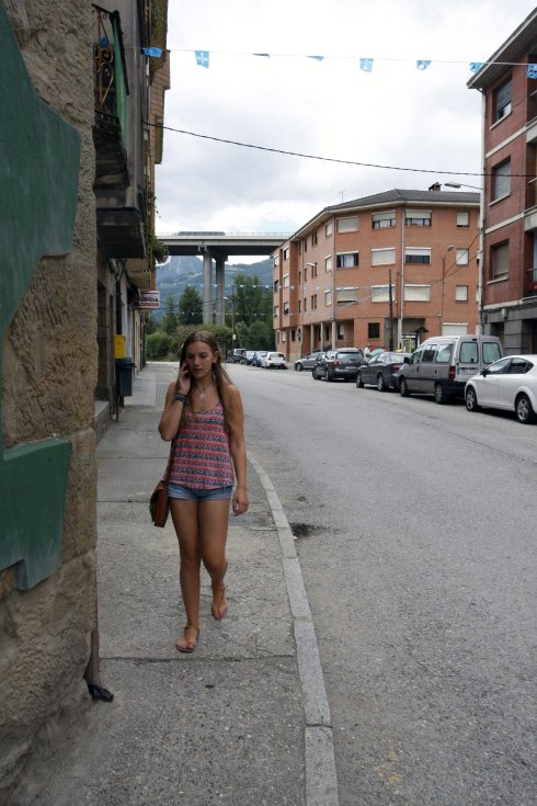 Una joven camina por una zona, cuyo asfaltado y arreglo piden los vecinos de Campomanes. 