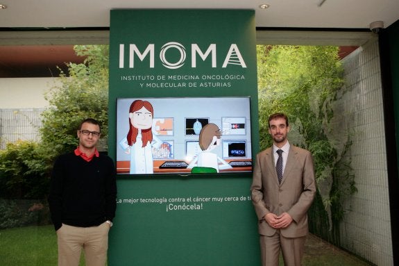 Juan Cadiñanos (izq.) , responsable del  laboratorio de Medicina Molecular y Rubén Cabanillas, director del IMOMA, en el estand. :: NAVARRO