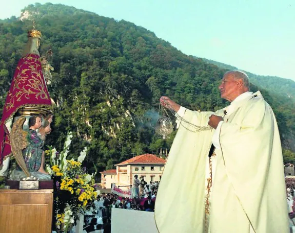 Juan Pablo II frente a la imagen de la Vigen de Covadonga, rodeada de flores y numerosos fieles. 