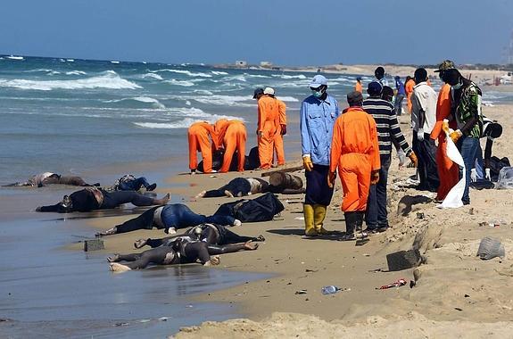 Personal de rescate recoge los cuerpos de los emigrantes africanos que fueron arrastrados a la costa de Qarboli, a 60 kilómetros de Trípoli (Libia), ayer, lunes.