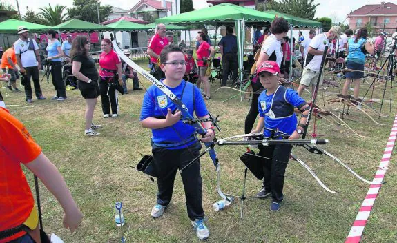 Dos niños se disponen a lanzar sus flechas. 