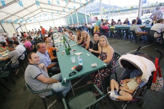 Los vecinos disfrutan de una paella gigante. 