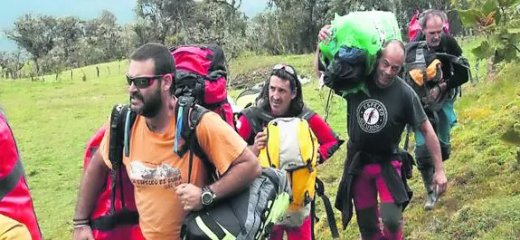 Joaquín Pérez -segundo por la derecha- carga con parte del equipo de rescate junto a otros voluntarios. En la otra imagen, Juan Carlos Riobello. 