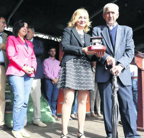 Enrique Miranda, de 92 años, recibe e Premio al cosechero de más edad de manos de la alcaldesa de Piloña, Carmen Barrera. 