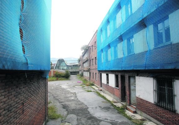 Antiguas dependencias de la Benemérita en Langreo, con una malla y ventanas tapiadas. 