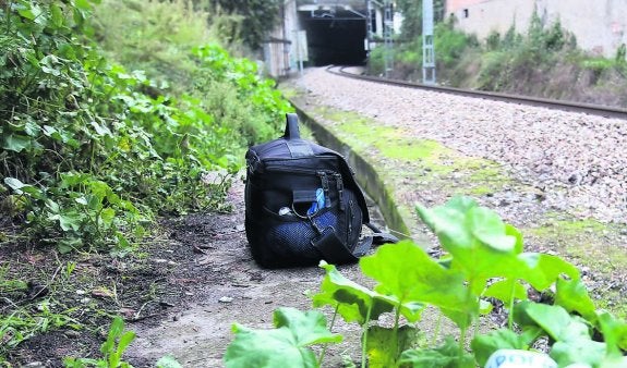 El maletín de la Policía Científica, ayer junto a las vías del tren. 