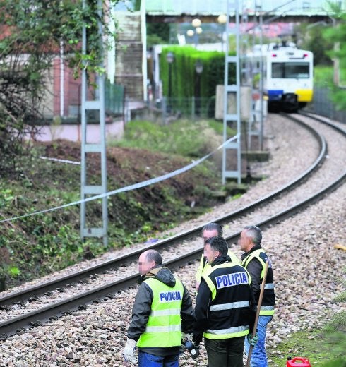 Los agentes conversan con el encargado del desbroce frente al lugar donde apareció el cuerpo del menor.