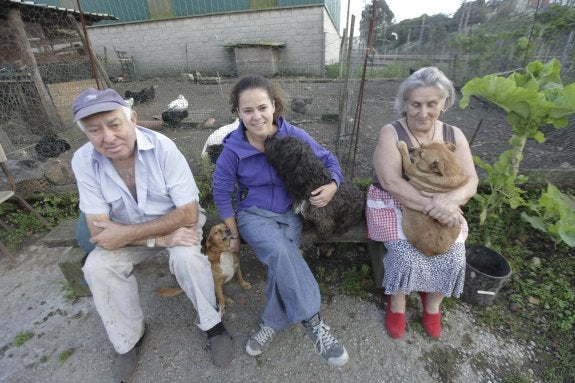 Juan, Maeva y Berta Sarasola, con alguno de los perros de su finca de Nubledo. 