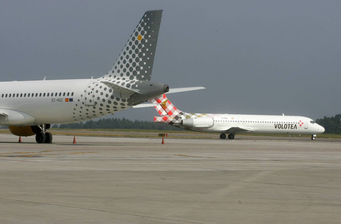 Una aeronave de Volotea, en el aeropuerto de Asturias, tras la cola de una de Vueling. 