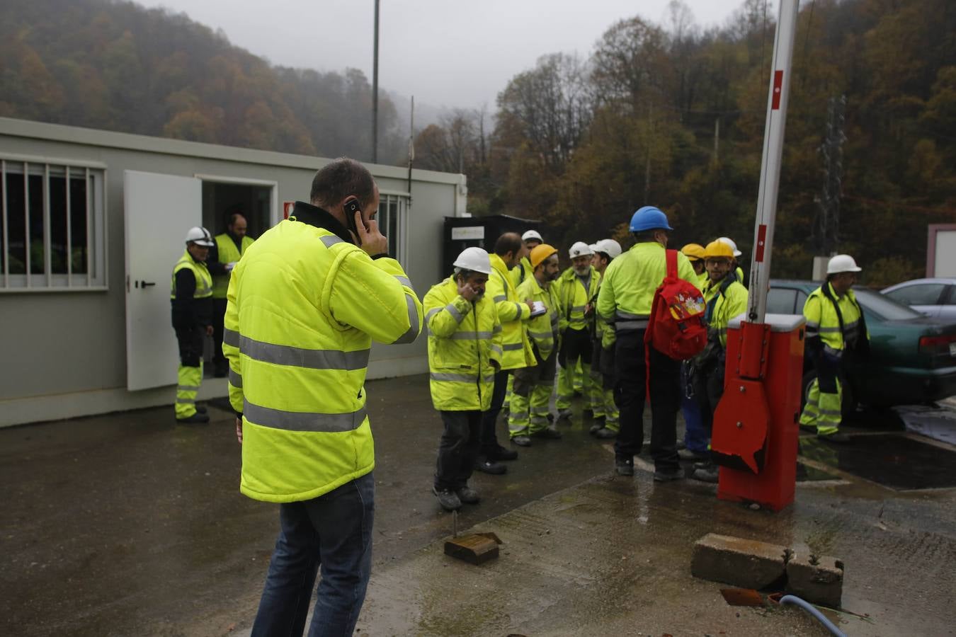 Trabajadores en la parte asturiana de la obra, llamando a sus familiares tras ser evacuados por el accidente en la otra vertiente. 