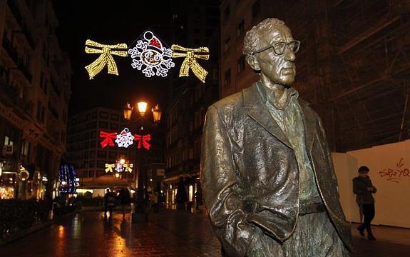 La estatua de Woody Allen, con las luces de Navidad al fondo.