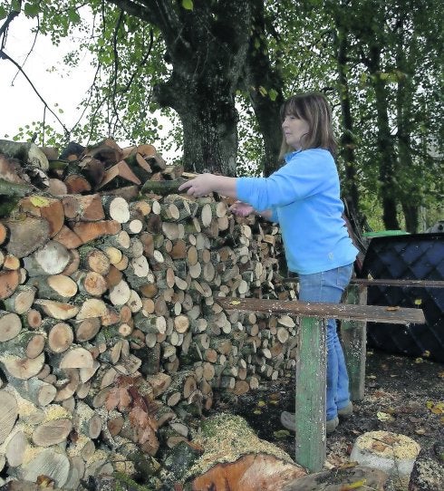 A las puertas de casa de Emma Martínez se dibuja una montaña de leña que servirá para mantener su hogar caliente durante todo el invierno.
