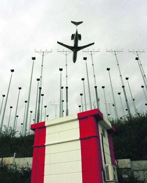 Un avión desciende cerca de las antenas situadas en la vaguada aledaña a la pista y cuya rigidez contravendría la norma. 